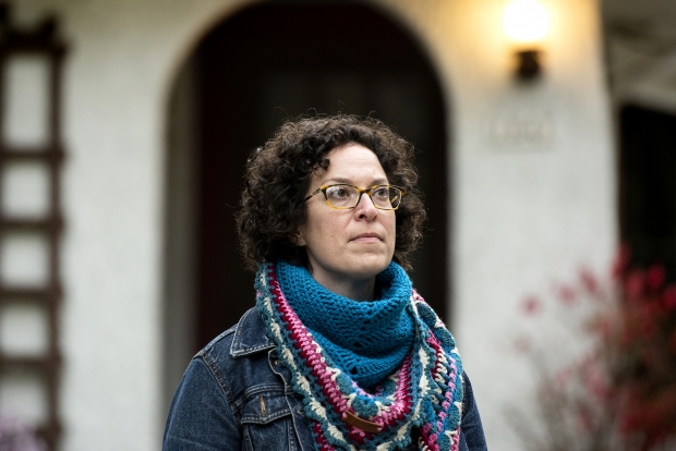A woman standing with a serious expression