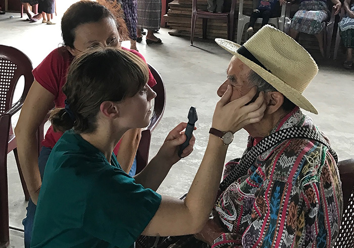 Woman examining the eye of a man