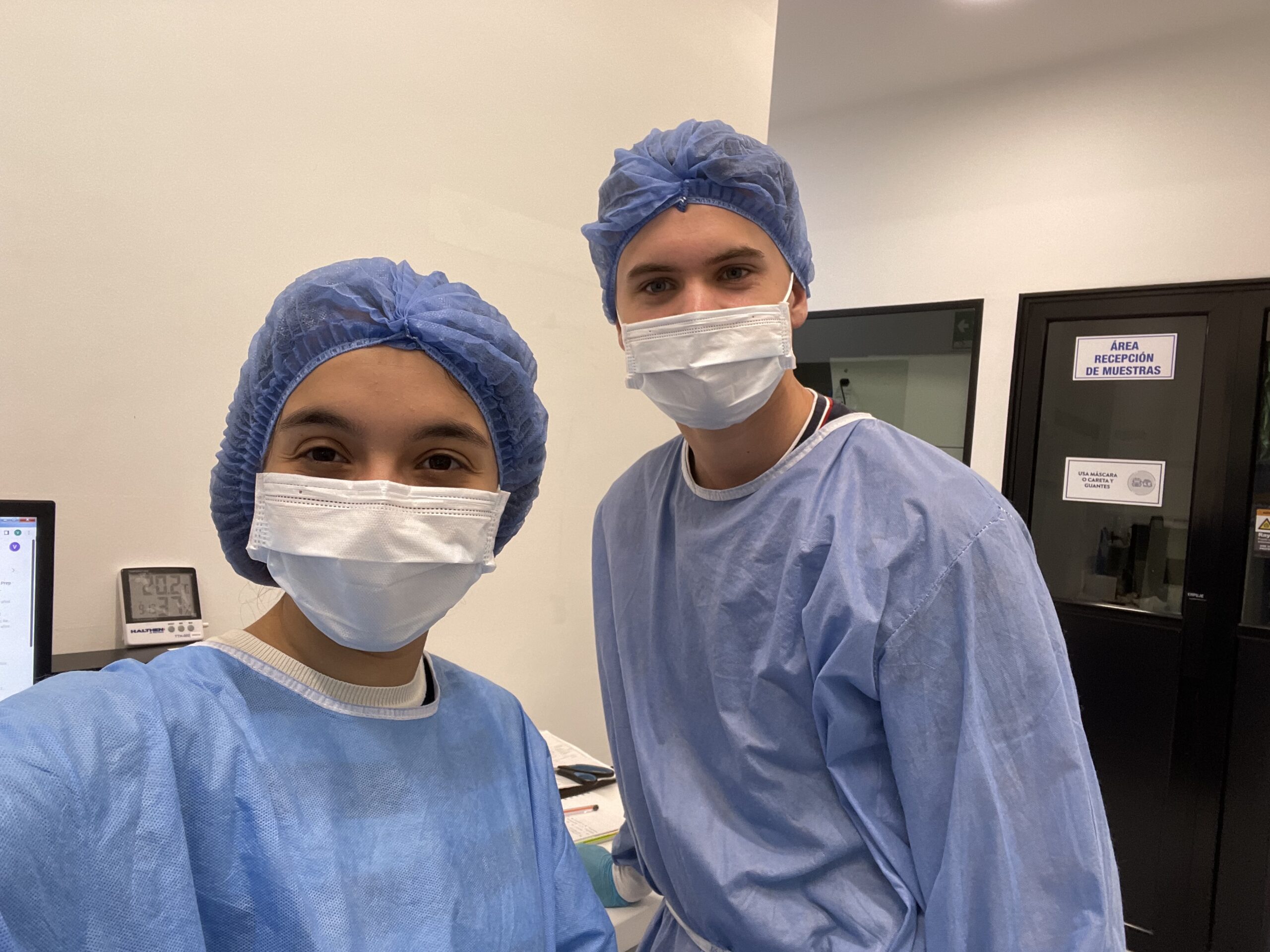 two people in scrubs and masks in a lab