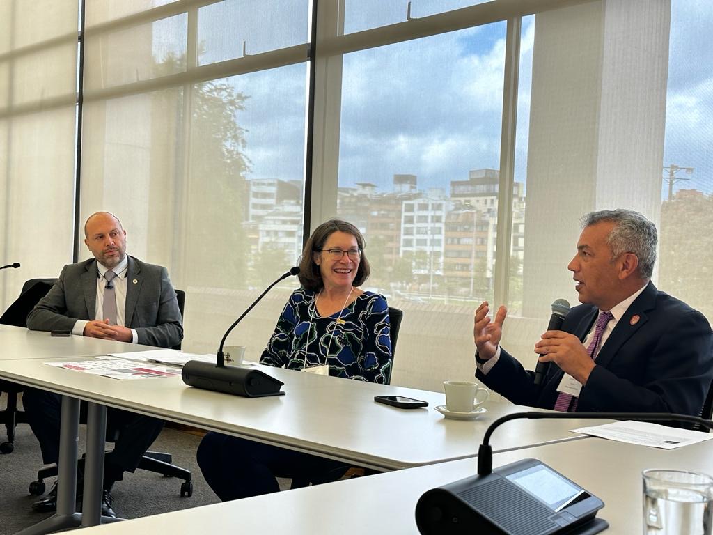 UNAL Vice Chancellor for Research, Juan Camilo Younes, UW Madison Vice Chancellor & International Division Dean Frances Vavrus, and UW Madison Global Health Institute Director Jorge Osorio (with mic) sitting at a conference table with windows in the background at UNAL Bogota, September 2023