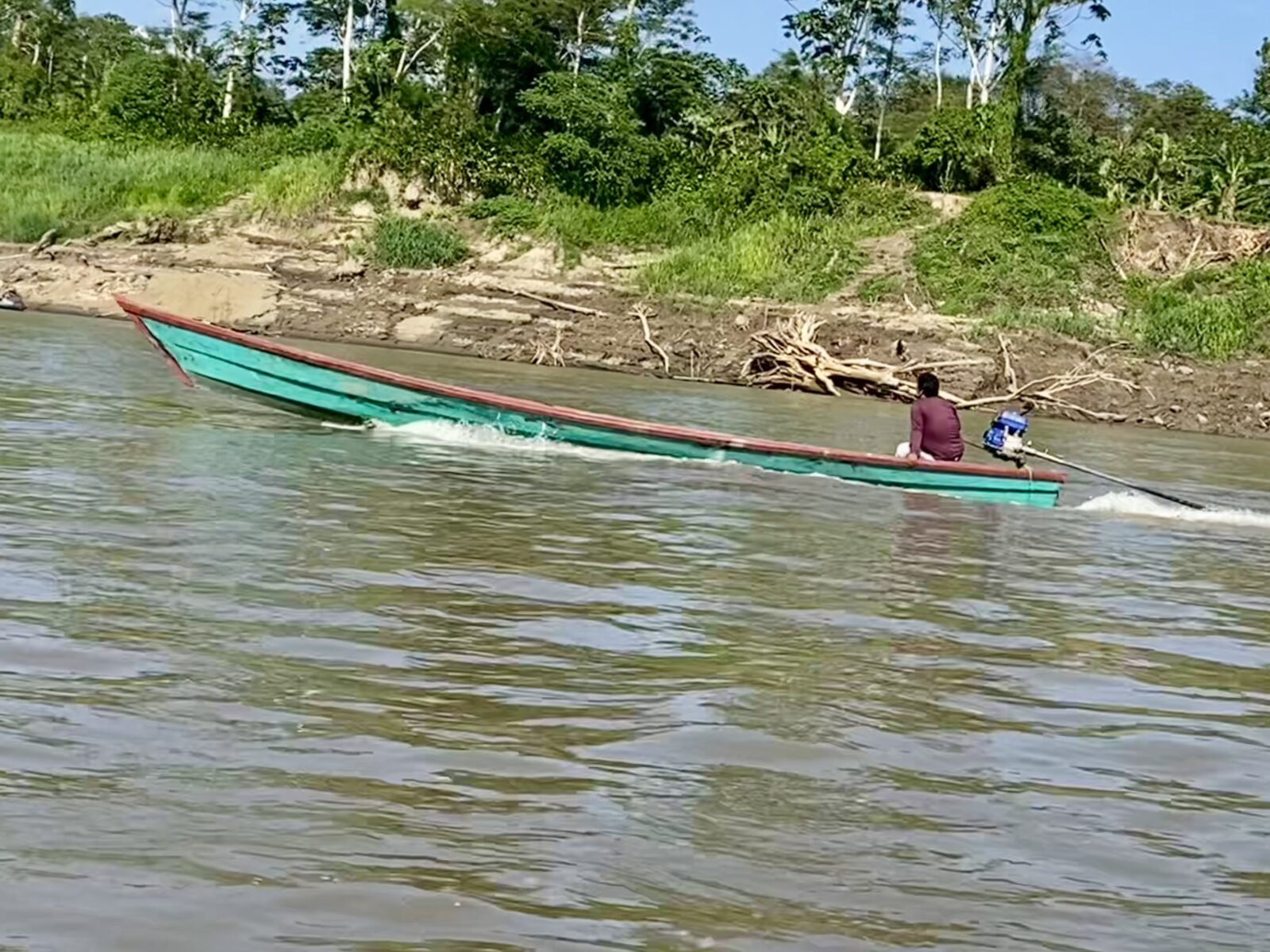 Water and shore views with a green boat from the Amazon River, Sept 2023