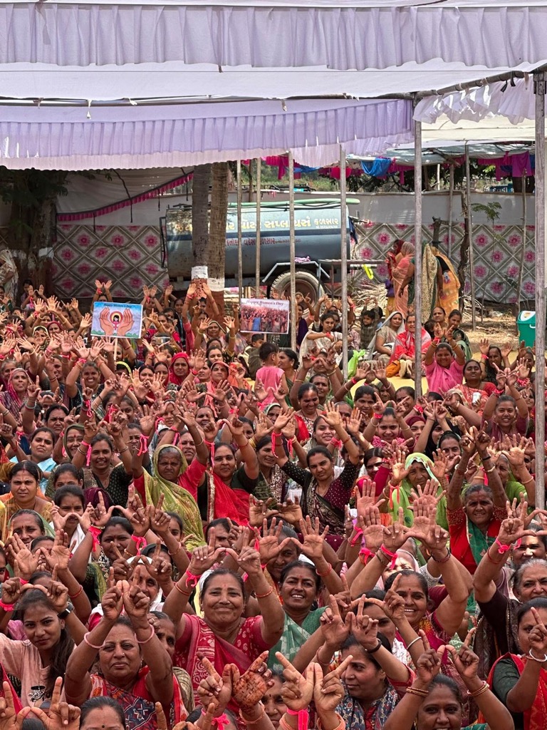 Women show their Badger pride by holding up the 'W' as UW delegation members reflected on women in the workforce (Photo from GHI)