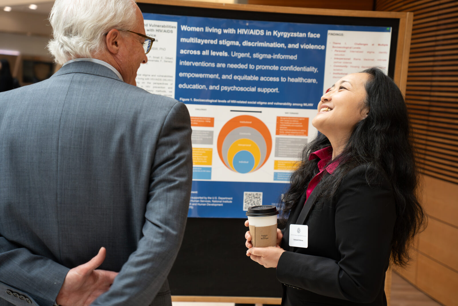 Photo from 2026 Global Health Symposium at the Discovery Building; Dr Conway and Saltana Childress in front of a poster