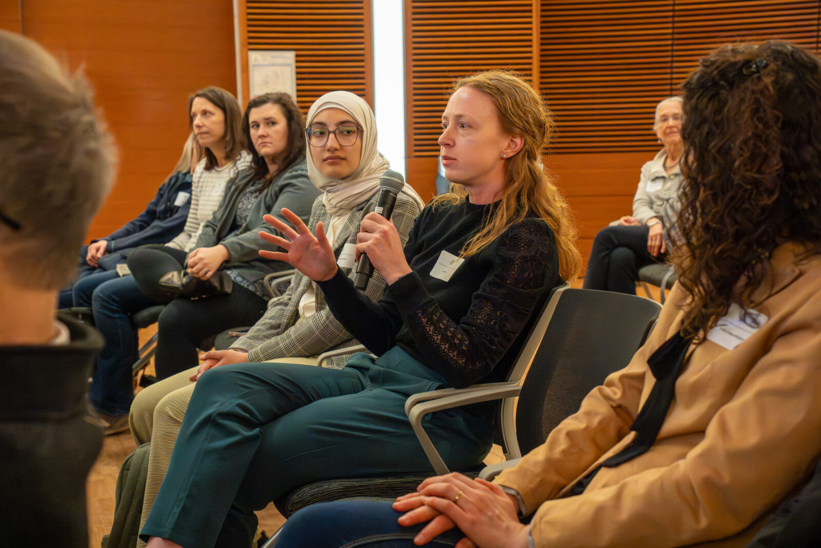 Photo from 2026 Global Health Symposium at the Discovery Building; a student in a black shirt sitting with a microphone in a crowd