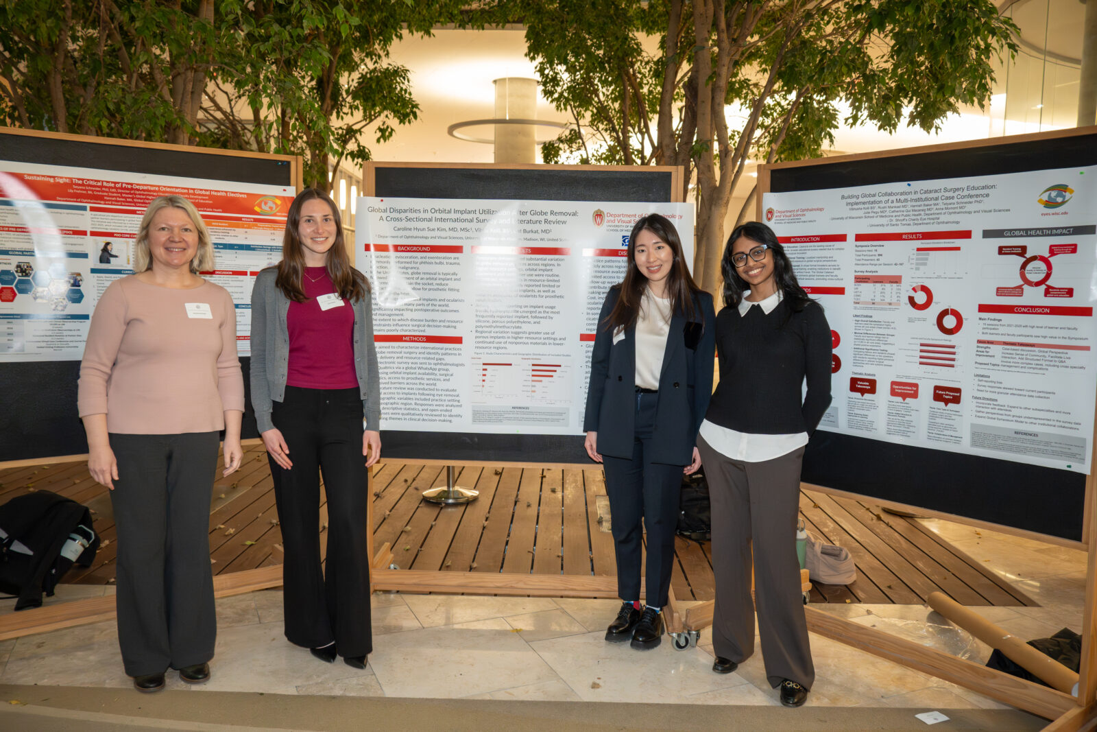 Photo from 2026 Global Health Symposium at the Discovery Building; four women standing in front of their posters