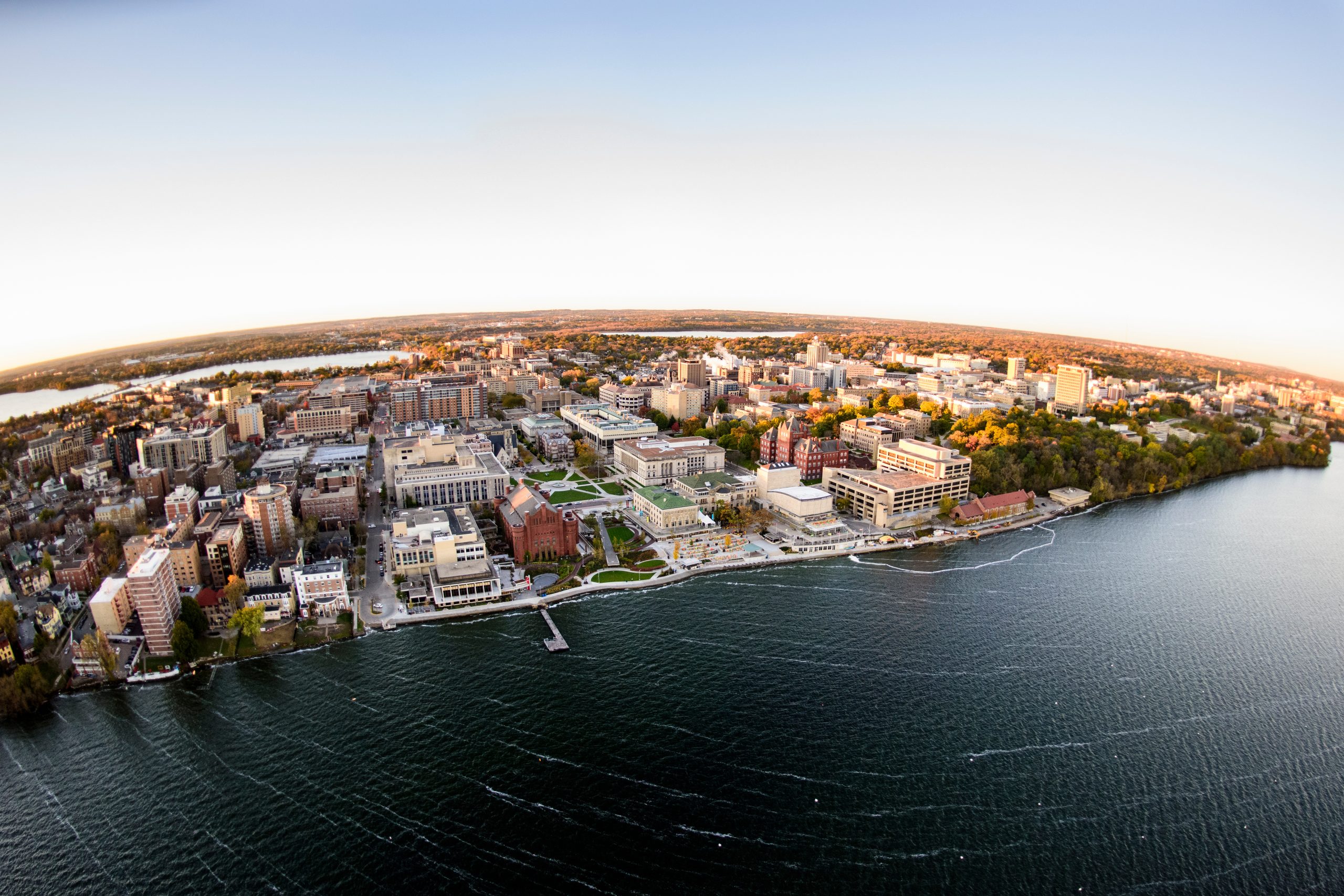 Lake Mendota and the University of Wisconsin-Madison campus, including the Memorial Union Terrace, are pictured in an early morning aerial taken from a helicopter on Oct. 23, 2018. This photograph was captured with a fisheye lens. (Photo by Bryce Richter /UW-Madison)