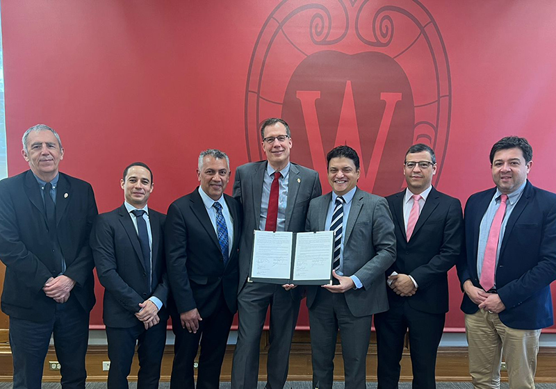 May 2022 Officials standing in a line and holding new agreement with UW-Madison.