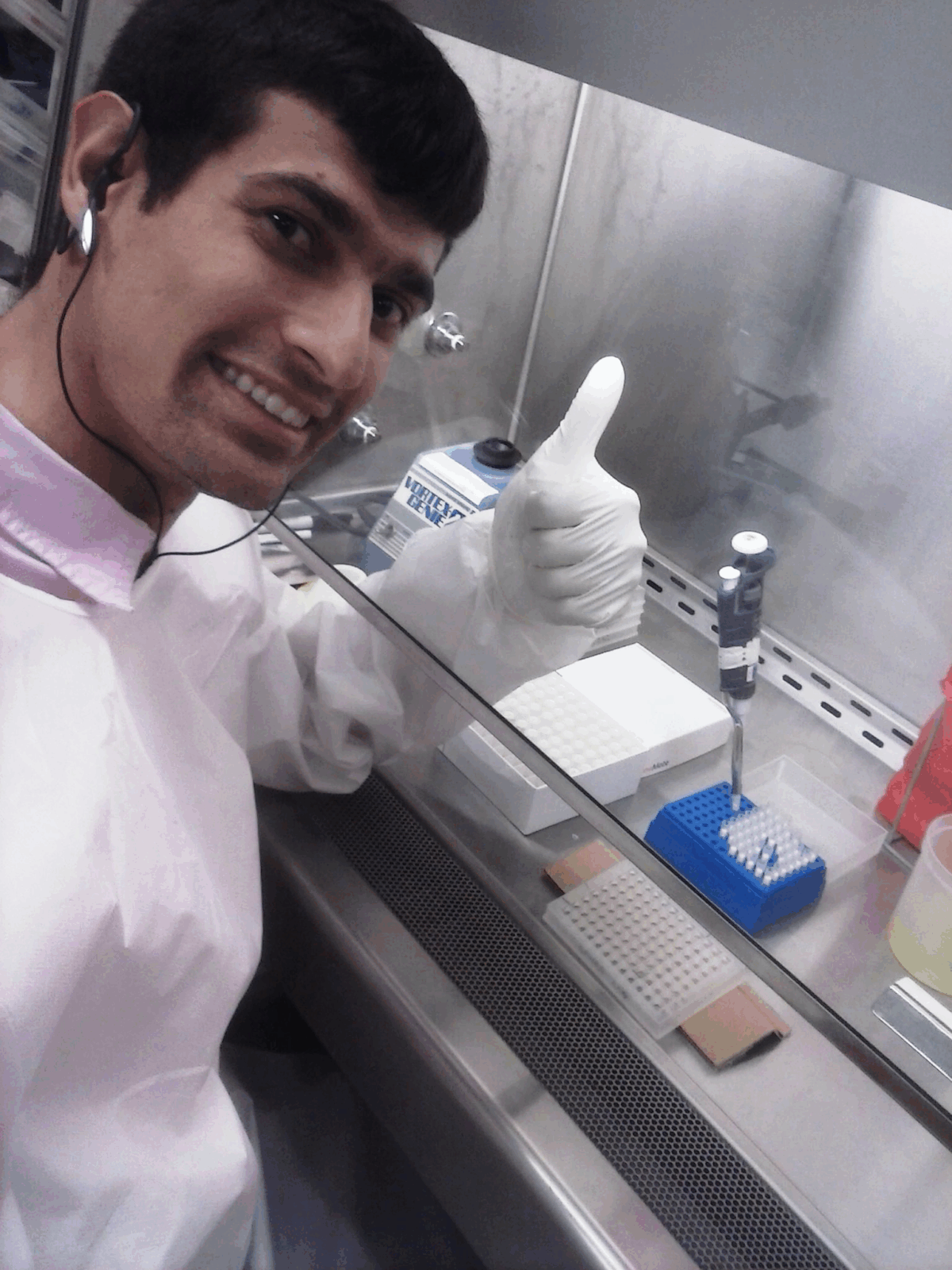 January 2024 From Treating to Preventing, man with dark hair in white PPE giving a thumbs up in a lab setting
