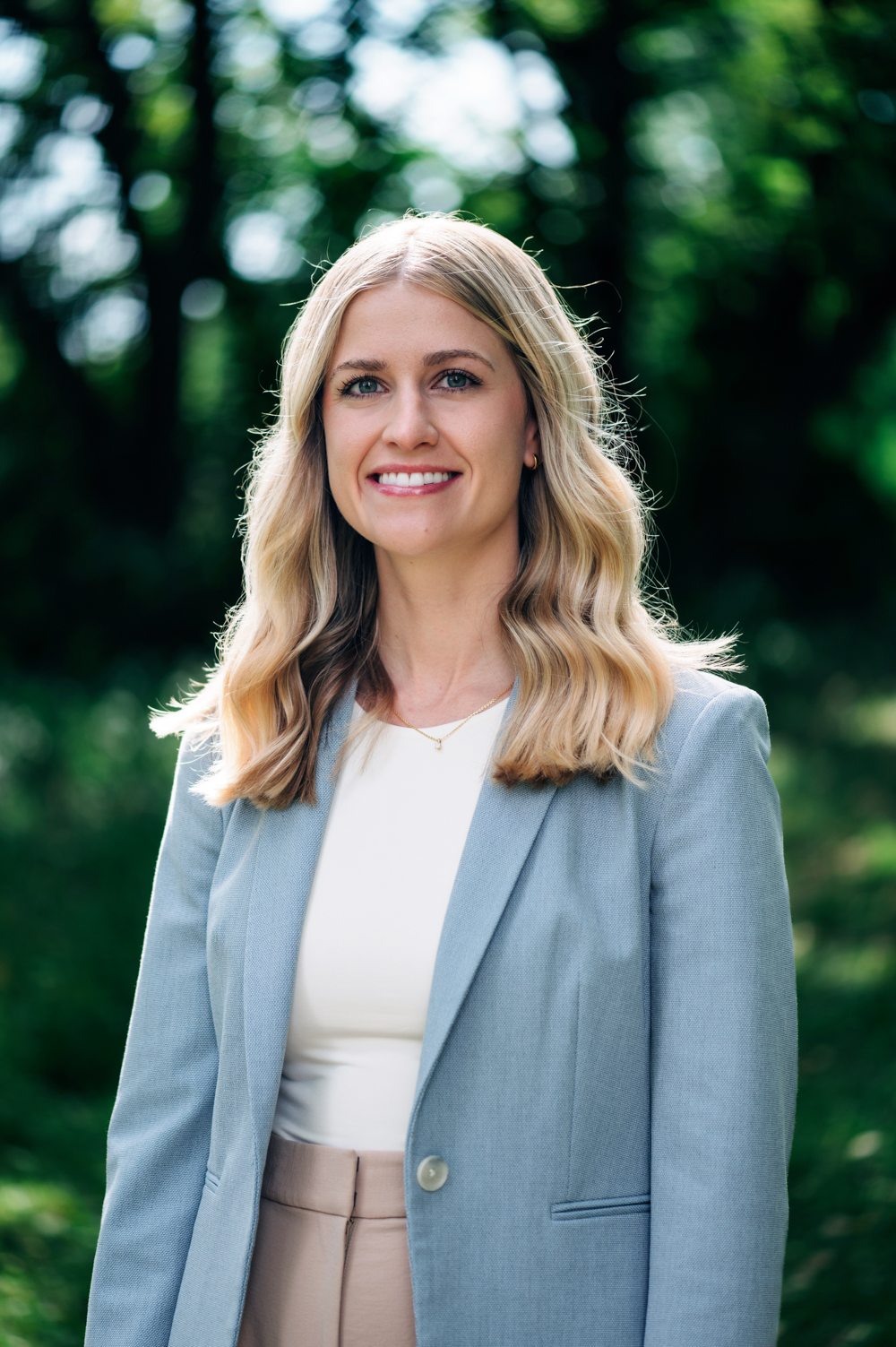 November 2023 Global Health Tuesday: Energy Challenges, woman with blonde hair, light blue jacket, white shirt against a nature background