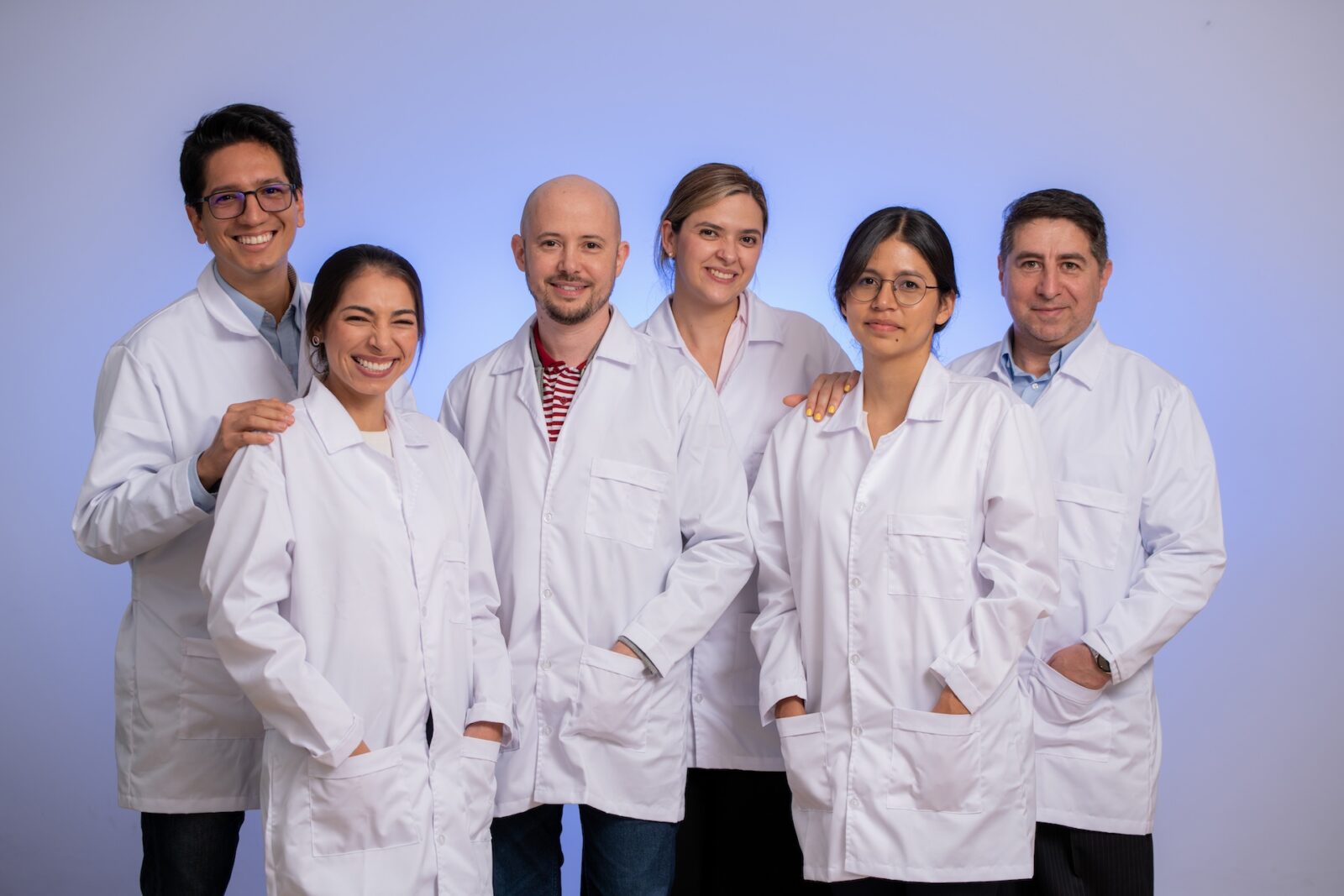 June 2024, group of people in white lab coats in front of a blue and purple background