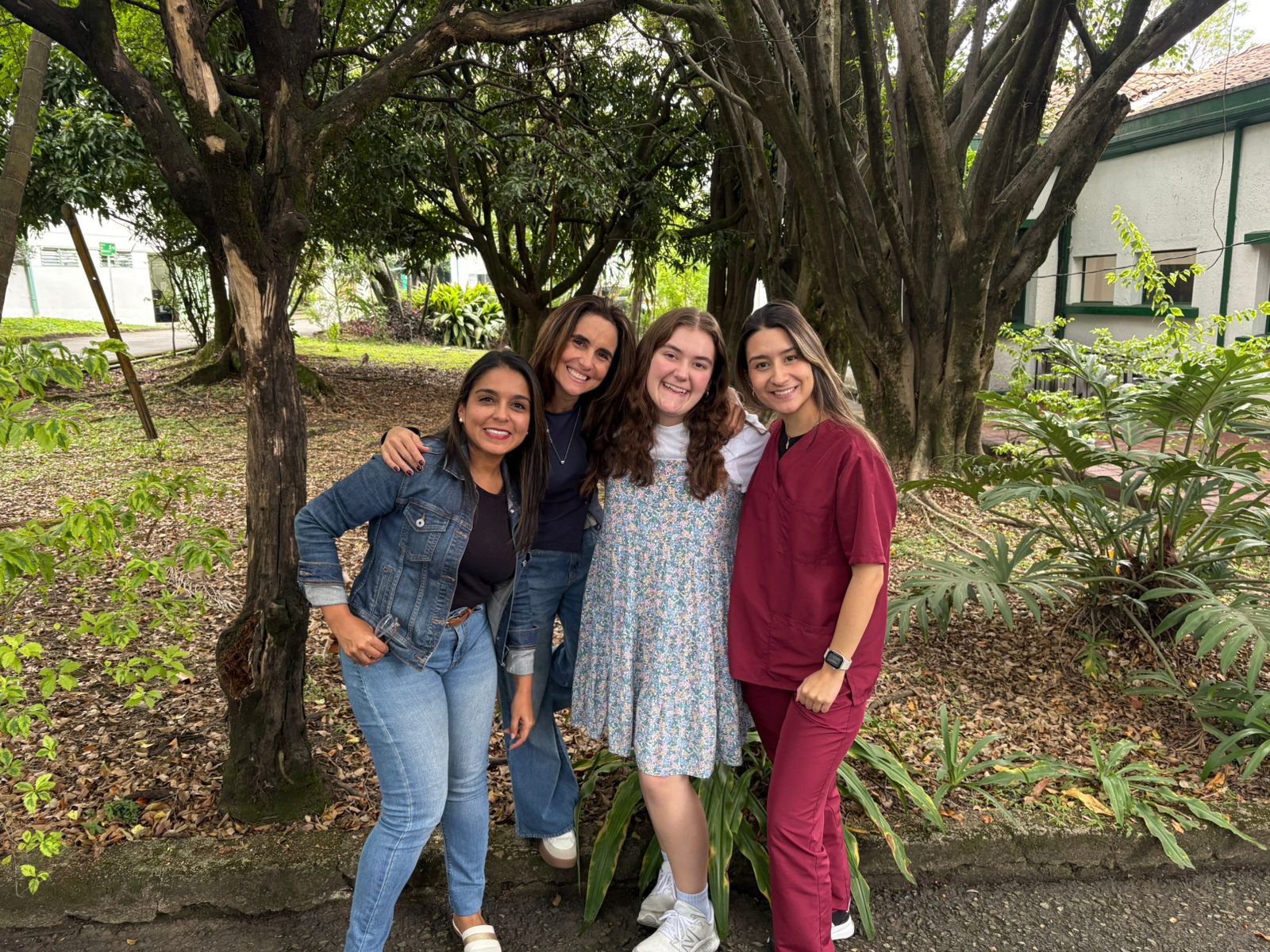 Four women standing in front of a forest background