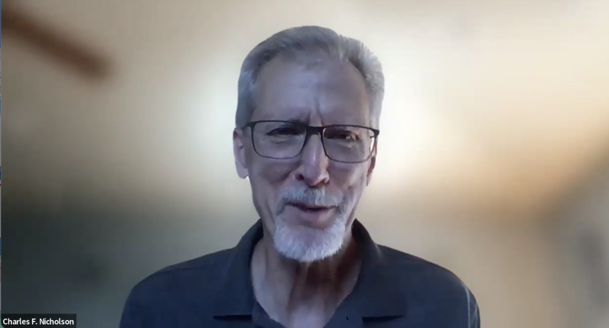 Screenshot of Dr. Charles F. Nicolson Aug 2026; man with white hair and beard, with glasses and a dark blue shirt against a beige gradient background