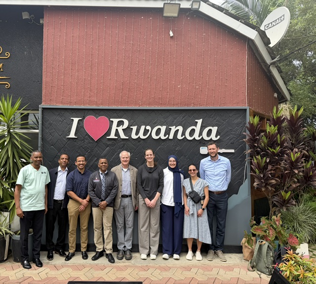 group of people standing in front of a building with the phrase: I (image of a red heart) Rwanda