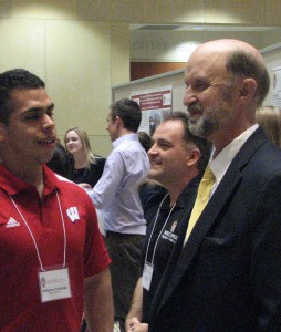 Dr. Christopher Olsen, right, keynote speaker, visits with a presenter during the 10th annual Global Health Symposium.