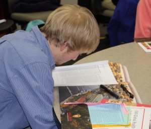 A high school student studies global health materials, including the stories of four girls named Anna who live in significantly different economic circumstances around the world. Students learned how a problem can have radically different outcomes, depending on access to care.