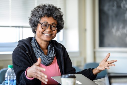 An enthusiastic woman of color presents ideas to a group
