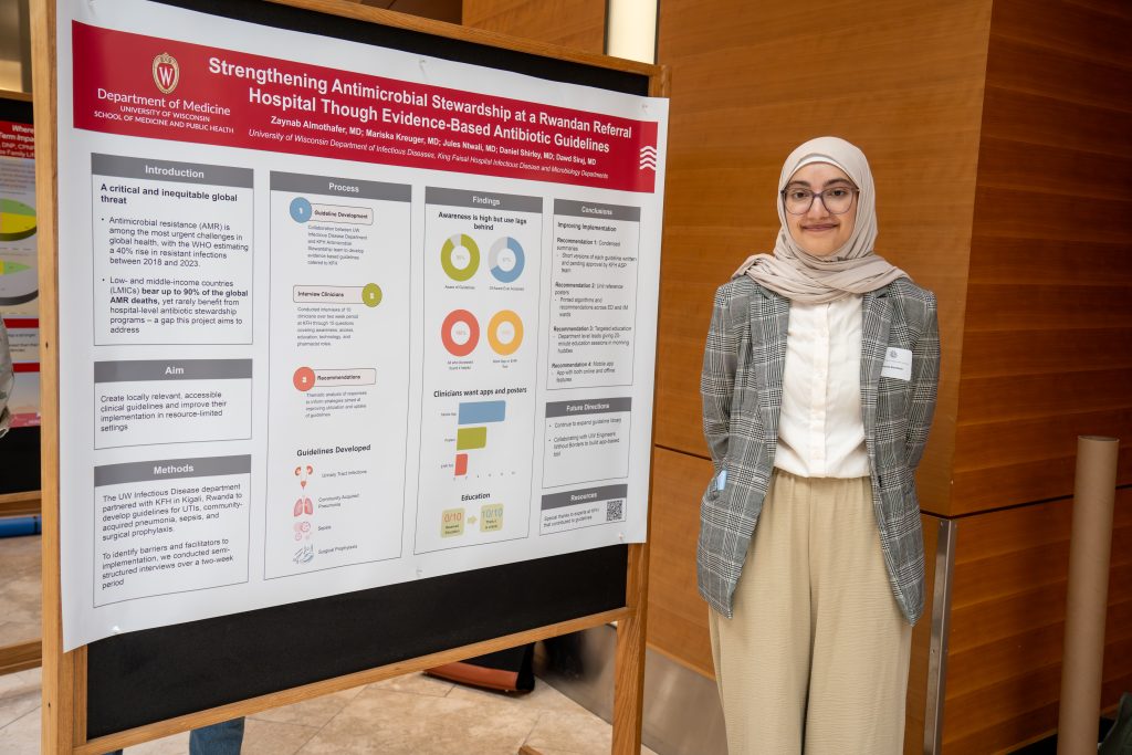 Photo from 2026 Global Health Symposium at the Discovery Building; woman in hijab wearing glasses standing in front of poster