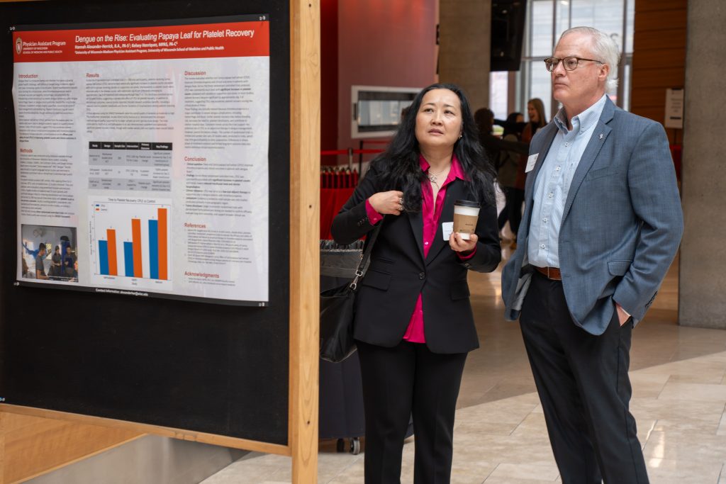 Photo from 2026 Global Health Symposium at the Discovery Building; Dr Conway and Saltana Childress in front of a poster