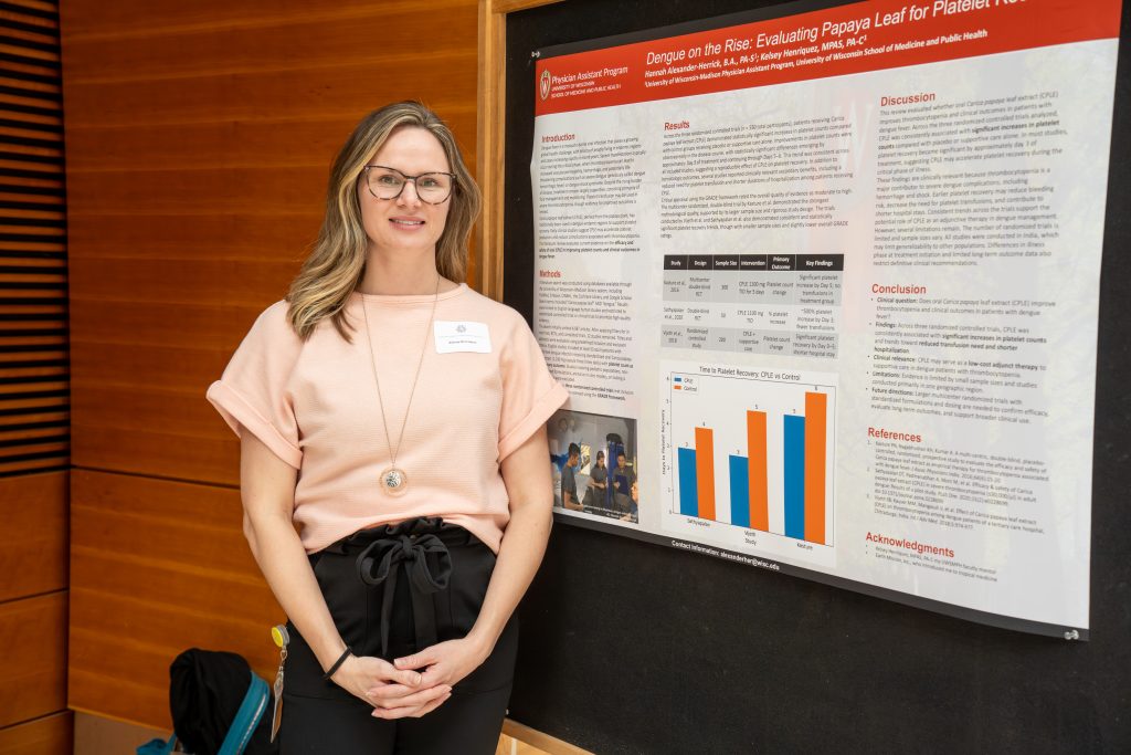 Photo from 2026 Global Health Symposium at the Discovery Building; woman with a pink shirt in front of a poster