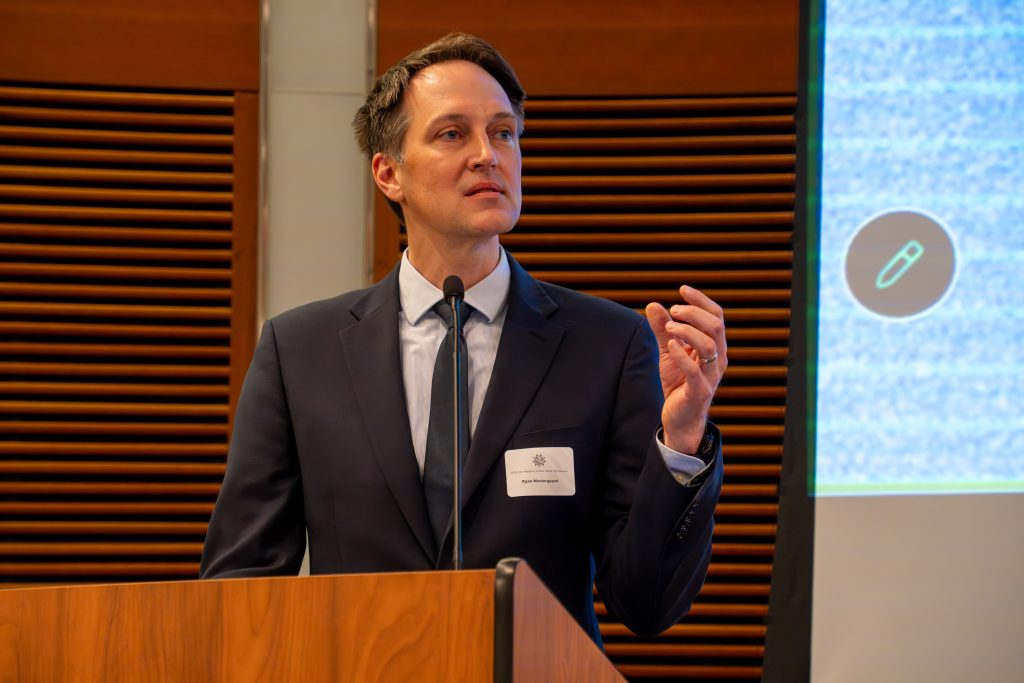 Photo from 2026 Global Health Symposium at the Discovery Building; Dr Westergaard at lectern with hand raised