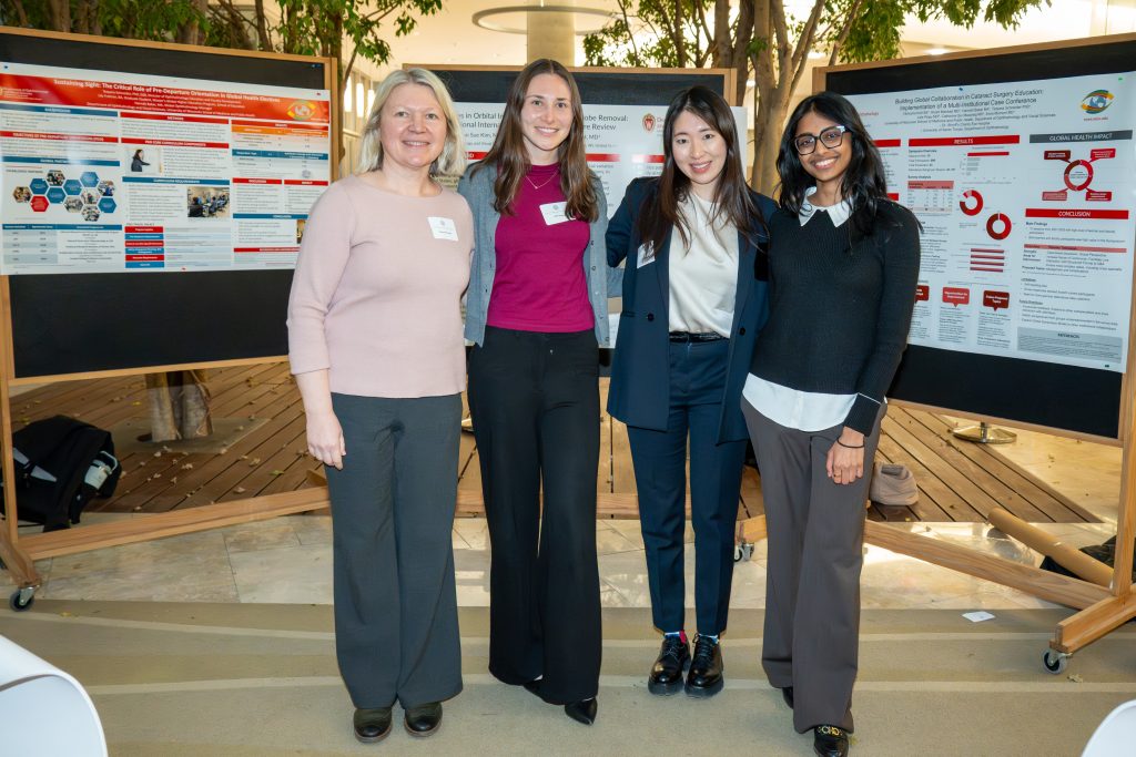 Photo from 2026 Global Health Symposium at the Discovery Building; four women standing in front of their posters